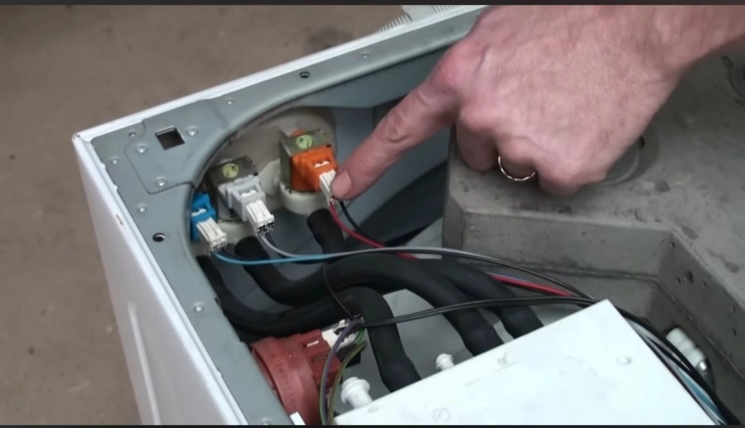 Technician checking a washer drain pump filter during a repair visit