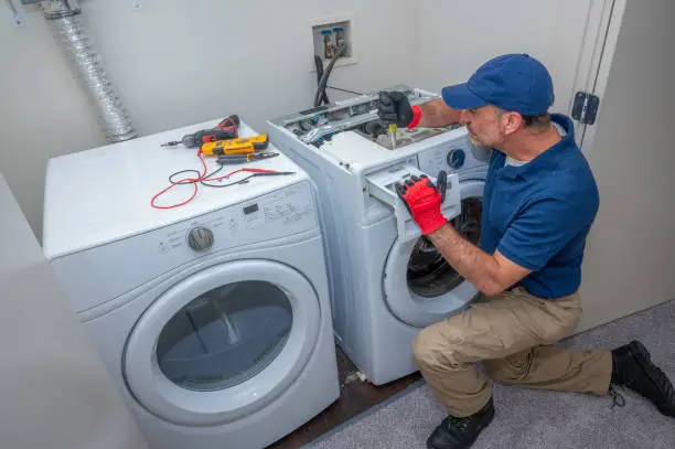 Washer repair technician servicing a washing machine in a Colorado Springs home